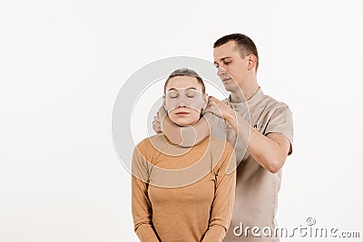 Neurosurgeon puts cervical soft collar or neck brace bandage on young woman to support and immobilize neck or for treat Stock Photo