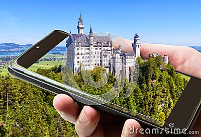 Neuschwanstein castle in Bavaria, Germany. Taking picture of fairytale castle by mobile or cell phone, photo of landscape Stock Photo
