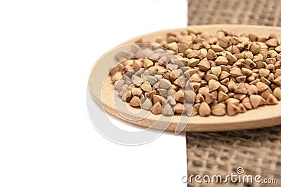 Neutral background. Buckwheat grains. Healthy food. Wooden spoon Stock Photo