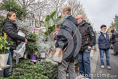 Customers are interested in flowers and other plants offered at a spring garden market Editorial Stock Photo