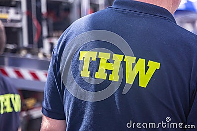 a volunteer of the German `Technisches Hilfswerk` Federal Agency for Technical Relief with the sign `THW` on his back Editorial Stock Photo