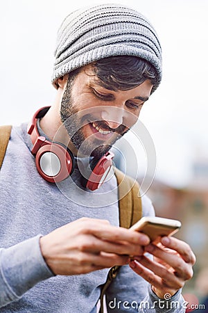 Never alone with social media. a young man using his mobile phone while out in the city. Stock Photo