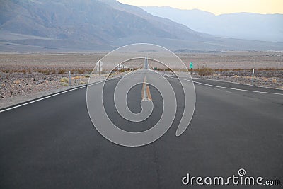 The never ending road during the dusk of a sunset in the Death Valley desert Stock Photo