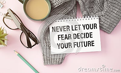 Never let your fear decide your future, text words typography written on book against wooden background Stock Photo