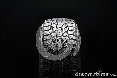 new all terrain tire. All-road universal tire tread with ground hooks on a black background Stock Photo