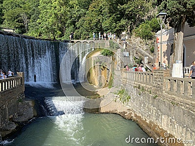 New Athos, Abkhazia, August, 09. 2019. People walking near artificial waterfall on the river Psyrtskha in the summer, the city of Editorial Stock Photo