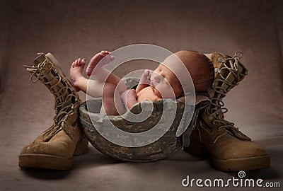 Newborn in Military Helmet Stock Photo