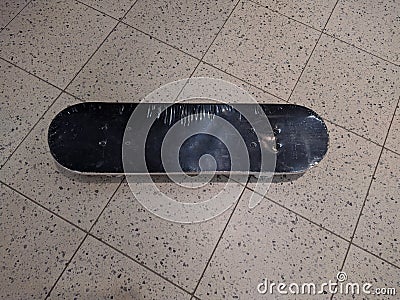 new and black skateboard on a tile background Stock Photo