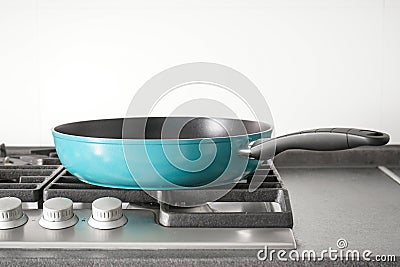 New blue frying pan on the gas stove Stock Photo