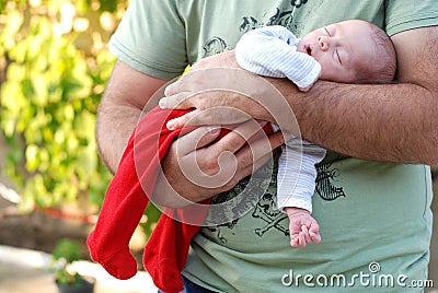 New born baby girl sleeping in her fathers arms Stock Photo