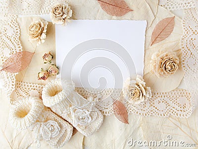 New Born or baptism Greeting Card. Blank paper with baby girl shoes on biege background. Flat lay. Top view. Stock Photo