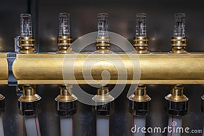 New brass manifold for underfloor heating systems with magnetic rotameters, seen up close. Stock Photo