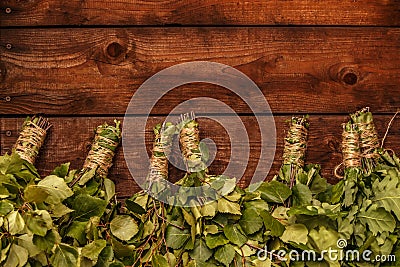 New brooms for a bath birch and oak branches on dark brown wooden background Stock Photo