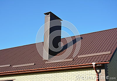 New brown metal tiled roof with plastic rain gutter system and chimney Stock Photo