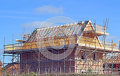 New build house with roof rafters and scaffolding. Stock Photo