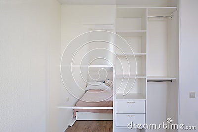 New built-in wardrobe in the bedroom - before and after installation. Modern furniture with mirror and shelves Stock Photo