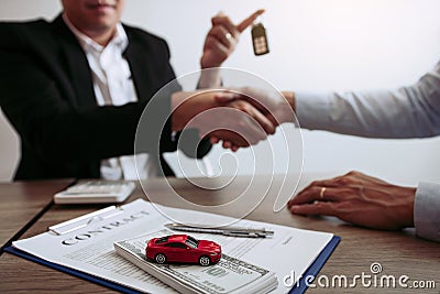 New car buyers and car salesmen are shaking hands to make agreements about car sales Stock Photo