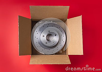 New car parts. Box with a new ventilated brake discs on a red background. Stock Photo