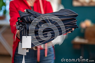 Hands holding out stack of clothes to camera Stock Photo