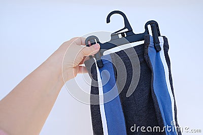 New colorful boxer, underpants on hanger in female hand, close up. Cotton panties for men, mens underwear, checks their quality, Stock Photo