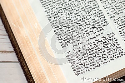 New commandment verse in open holy bible book with golden pages, close-up Stock Photo