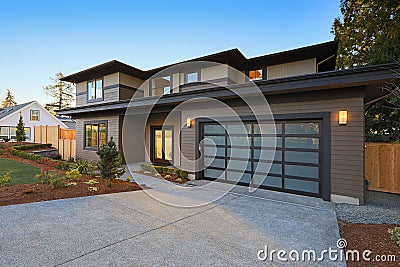 New construction home with low slope roof and brown siding. Stock Photo