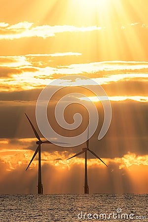 New dawn. Offshore wind turbines silhouetted by beautiful sunrise Stock Photo