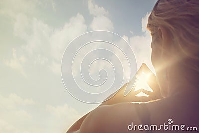 A new day begins with the sunrise protected in the hands of a woman Stock Photo