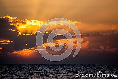 New day. Ocean dawn horizon with sun breaking behind cloud. Stock Photo