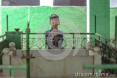 New Delhi, Delhi/ India- May 31 2020: A Small kid reading morning namaz near a darga in jama masjid Editorial Stock Photo