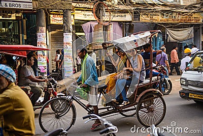 New Delhi, India - April 16, 2016 : Rickshaw rider transports passenger on April 16, 2016 in New Delhi, India. Cycle rickshaws Editorial Stock Photo