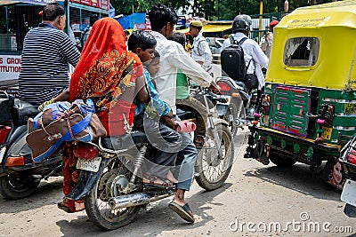 Dangerous travelling in India. The whole family, husband, wife and children on one motorcycle in traffic jam Editorial Stock Photo