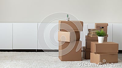 Heap of boxes with belongings stacked in empty living room Stock Photo