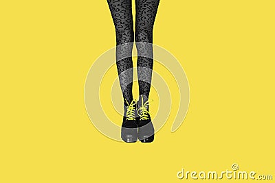 New gray female boots with bright yellow laces on straight, long slender woman legs in gray tiger print tights isolated on yellow Stock Photo