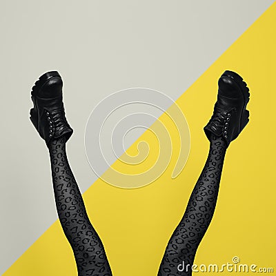 New gray female boots on long slender woman legs in gray tights isolated on yellow and gray background Stock Photo