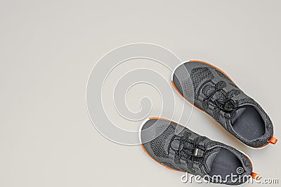 New grey children sneakers on gray background with copy space. Black and white image Stock Photo