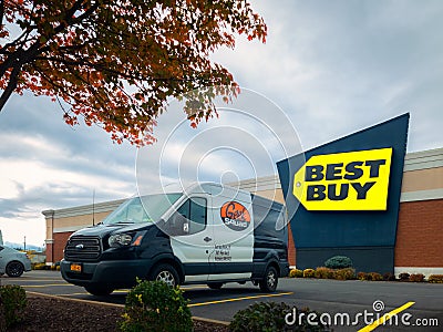 Landscape Wide View of Geek Squad Black and White Van in Foreground and Best Buy Building Editorial Stock Photo