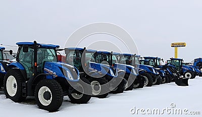 New Holland tractors lined up for sale on grey winter day Editorial Stock Photo