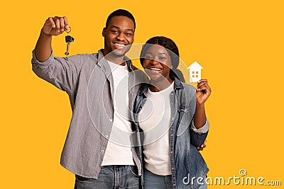 New Home Owners. Happy african american couple holding paper house and keys Stock Photo