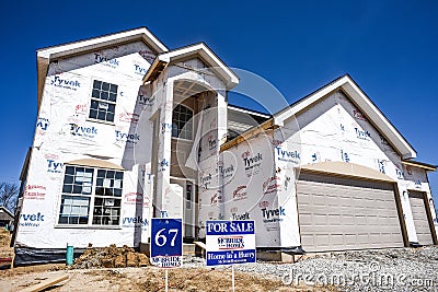 New home partially finished, under construction in residential housing subdivision with for sale sign in yard Editorial Stock Photo