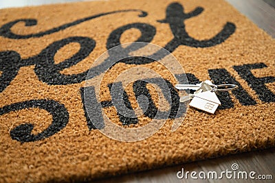 New House Keys and Keychain Rests on Home Sweet Home Welcome Mat Stock Photo