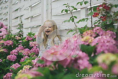 New life concept. Spring holiday. Childrens day. Small baby girl. Little girl at blooming flower. Summer. Mothers or Stock Photo