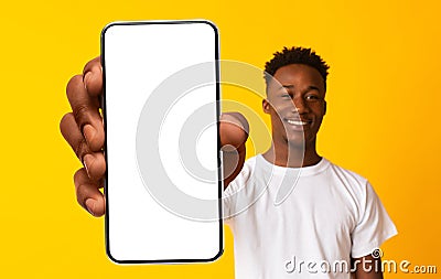 New mobile app ad. African american man showing white empty cellphone screen, recommending website or ad, mockup Stock Photo