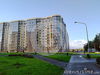 New modern apartment building with glass balconies. Residential area. A paved pedestrian road leads to the house. Realty. Copy the Editorial Stock Photo