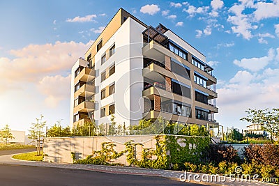 New modern block of flats in green area with blue sky Stock Photo