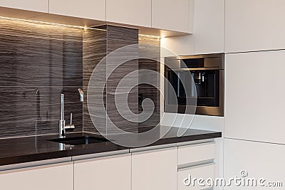 New modern kitchen with built in oven and chrome water tap. LED worktop illumination. Stock Photo