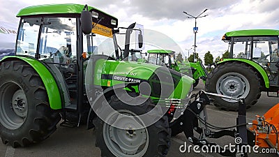 New modern versatile tractor Deutz Fahr with short wheelbase in agricultural machinery exhibition. Venue for farmers business. Sup Editorial Stock Photo