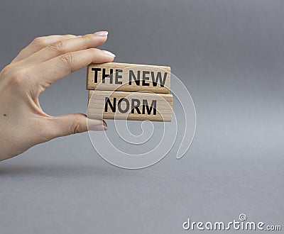 The new norm symbol. Concept words The new norm on wooden blocks. Beautiful grey background. Businessman hand. Business and The Stock Photo
