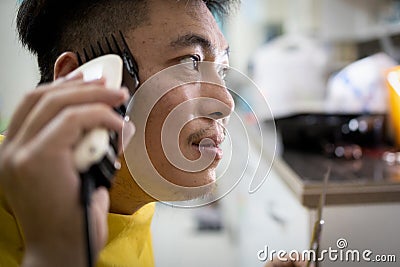 New normal,Asian man cut his own hair at home,stay home for the safety,people try not to go outside or the barber shop,haircut by Stock Photo