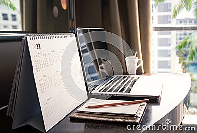 Desktop calendar 2022 on wooden desk in private office Stock Photo